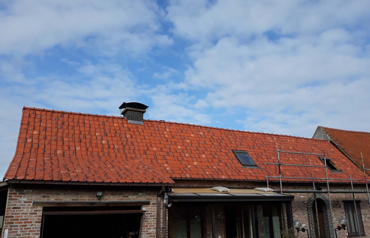 Dakrenovatie in uitvoering — stelling geplaatst, gevel in renovatie