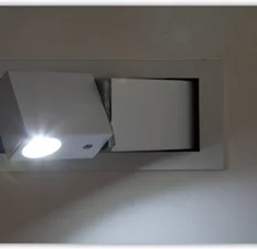 Moderne vlakke wandschakelaar met geïntegreerde leeslamp.